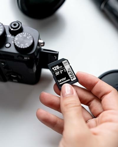 Main tenant une carte SD Lexar devant un appareil photo.