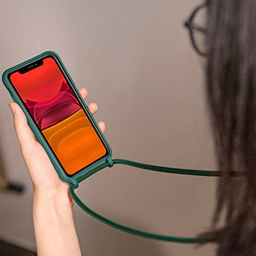 Personne tenant un smartphone avec une coque verte.