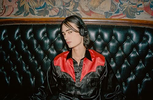 Personne portant un casque audio sur un canapé en cuir.